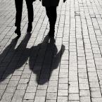 the shadows of two people walking together