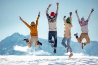 family dressed in winter clothes jumping in the air